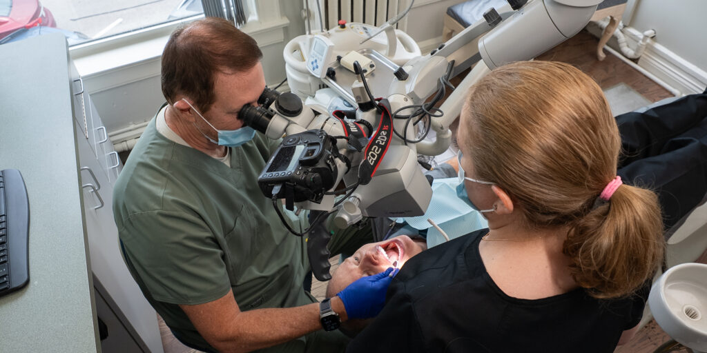 Dr. Kohler using microscope with staff member