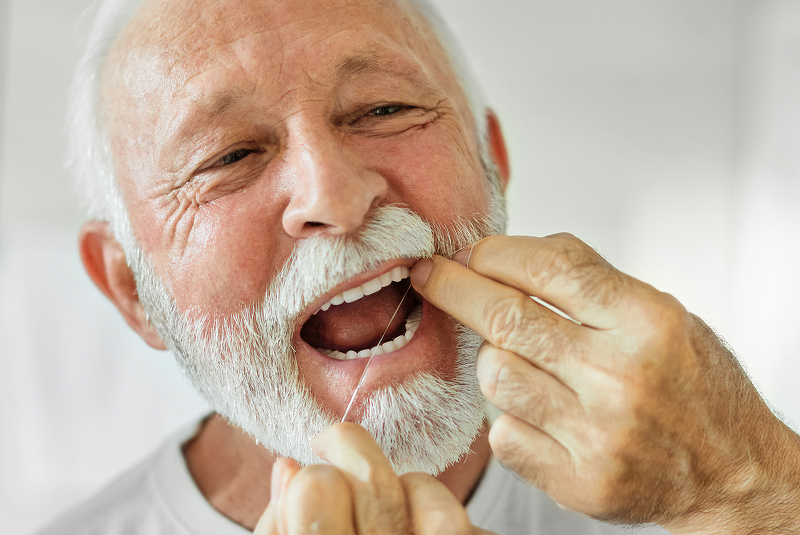 older man flossing